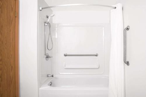 a bathroom with a shower with a white tub at Super 8 by Wyndham Portage La Prairie MB in Portage La Prairie