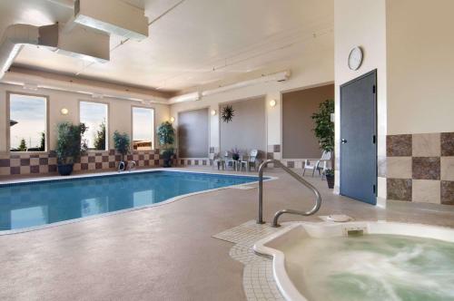 a large pool with a hot tub in a hotel room at Travelodge by Wyndham Stony Plain in Stony Plain
