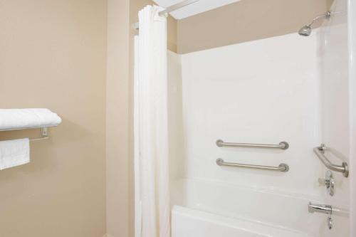 a bathroom with a shower with a shower curtain at Super 8 by Wyndham Talladega AL in Talladega