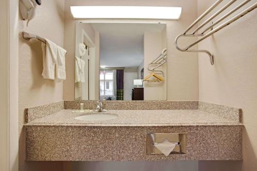 a bathroom with a sink and a mirror at Super 8 by Wyndham Oklahoma/Frontier City in Edmond