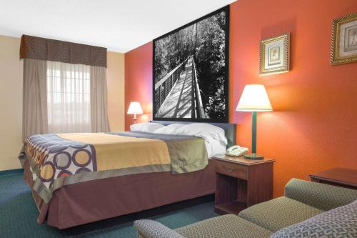 a hotel room with a bed and a telephone at Super 8 by Wyndham Talladega AL in Talladega