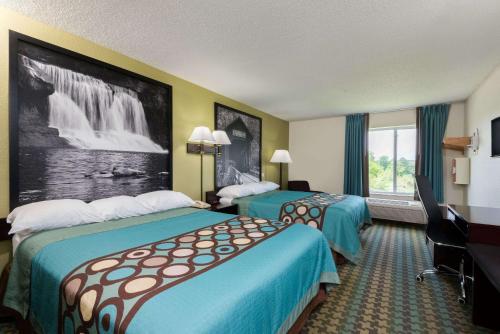 a hotel room with two beds and a desk at Super 8 by Wyndham Cloverdale IN in Cloverdale