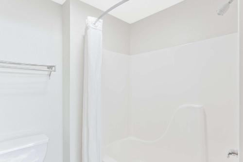 a bathroom with a shower curtain and a toilet at Super 8 by Wyndham Cloverdale IN in Cloverdale