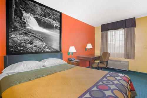 Super 8 by Wyndham Talladega AL في تالاديجا: غرفة في الفندق مع سرير ومكتب