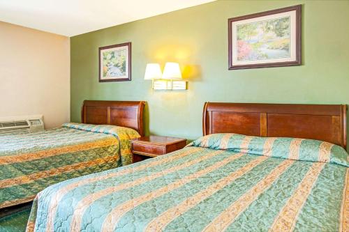 duas camas num quarto de hotel com paredes verdes em Knights Inn South Hackensasck em South Hackensack