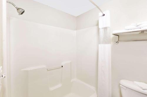 La salle de bains blanche est pourvue d'une douche et de toilettes. dans l'établissement Super 8 by Wyndham Mound City, à Mound City