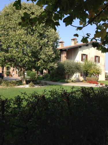 a large house with a tree in front of it at Le Rondini in Bagnolo Mella
