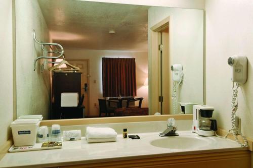 a bathroom with a sink and a large mirror at El Rancho Motel in Little Rock