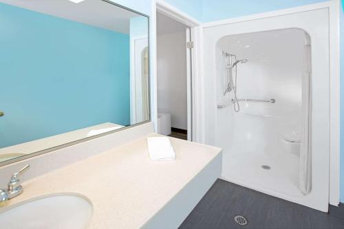 a white bathroom with a sink and a shower at Travelodge by Wyndham Bishop in Bishop