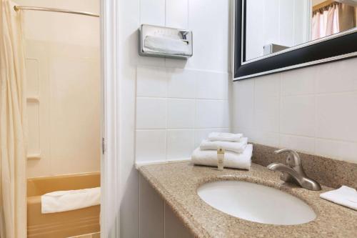 a bathroom with a sink and a mirror at Travel Inn Cochrane in Cochrane