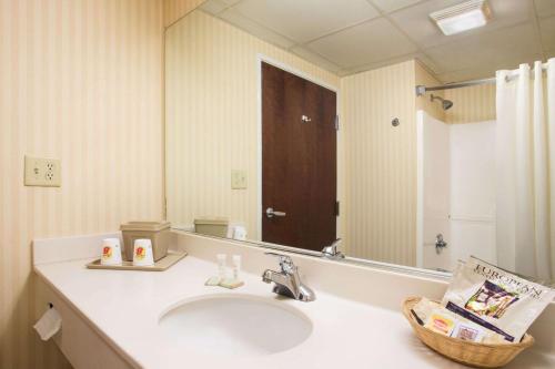 a bathroom with a sink and a large mirror at Super 8 by Wyndham Grayville in Grayville