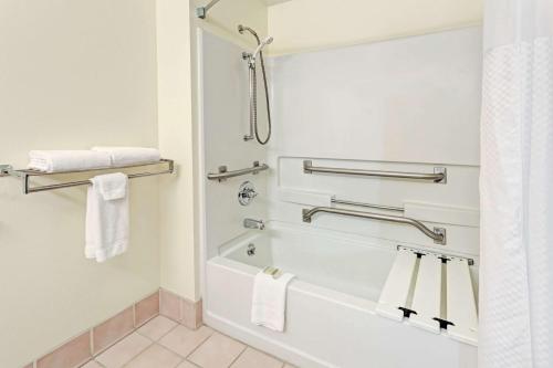 a bathroom with a tub and a shower with towels at Super 8 by Wyndham Windsor in Windsor