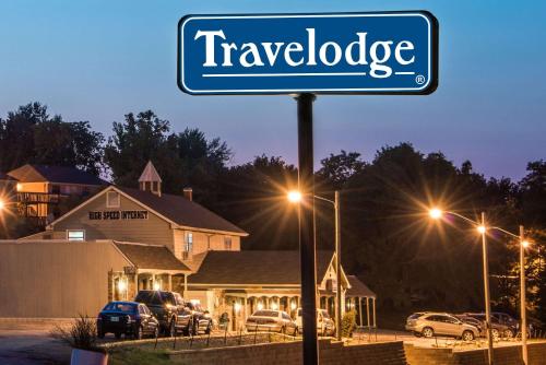 a blue sign that reads travelodge in front of a house at Travelodge by Wyndham Airport Platte City in Platte City
