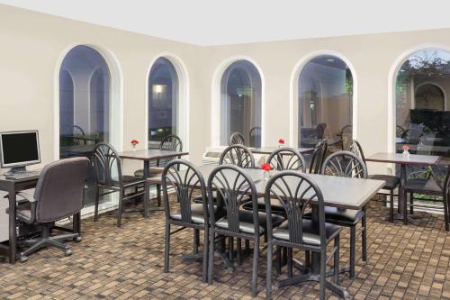 a group of tables and chairs in a restaurant at Super 8 by Wyndham Morton Grove/Chicago in Morton Grove