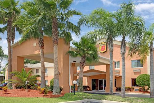 a hotel with palm trees in front of it at Super 8 by Wyndham Daytona Beach in Daytona Beach