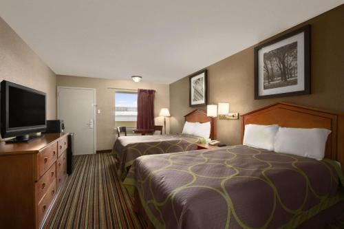 a hotel room with two beds and a flat screen tv at Super 8 by Wyndham Chattanooga/East Ridge in Chattanooga