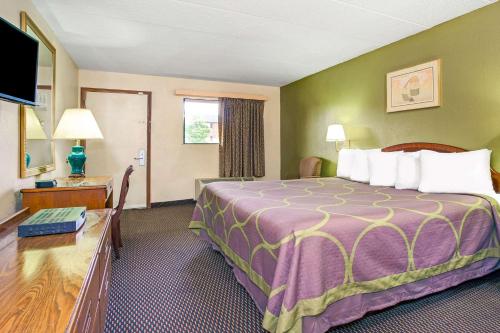 a hotel room with a large bed and a desk at Super 8 by Wyndham Fort Mitchell Cincinnati Area in Fort Mitchell
