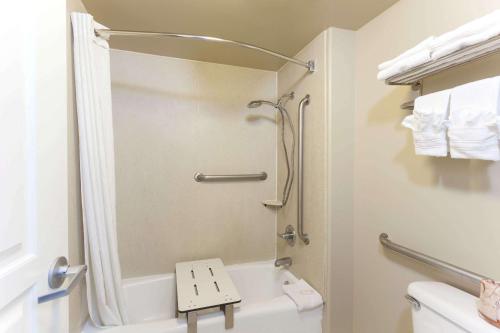 Super 8 by Wyndham Torrance LAX Airport Area في تورانس: حمام مع دش ومرحاض أبيض