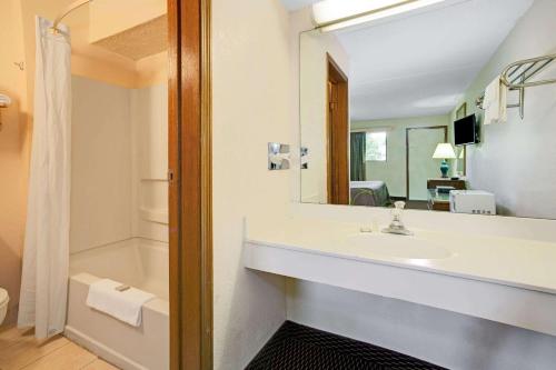 a bathroom with a sink and a mirror and a shower at Super 8 by Wyndham Fort Mitchell Cincinnati Area in Fort Mitchell