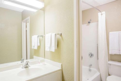 a bathroom with a sink and a toilet and a mirror at Super 8 by Wyndham Madison East in Madison