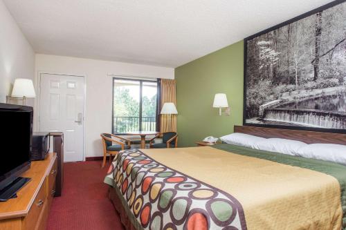 a hotel room with a bed and a flat screen tv at Super 8 by Wyndham Lavonia in Lavonia