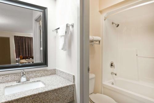 y baño con lavabo, aseo y espejo. en Super 8 by Wyndham Franklin Hwy 31, en Franklin