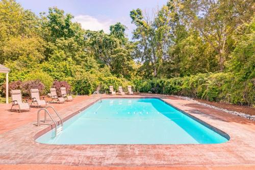 a swimming pool with lounge chairs and a swimming pool at Colonial Inn Seekonk in Seekonk