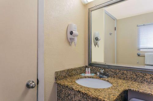 a bathroom with a sink and a mirror at Atlantic Inn in Virginia Beach