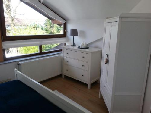 a bedroom with a window and a bed and a dresser at Ferienwohnung Wiesmühlstrasse in Henndorf am Wallersee