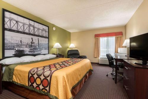 a hotel room with a bed and a flat screen tv at Super 8 by Wyndham Miamisburg Dayton S Area OH in Miamisburg