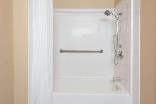La salle de bains est pourvue d'une douche avec rideau de douche. dans l'établissement Super 8 by Wyndham Sainte Agathe Des Monts, à Sainte-Agathe-des-Monts