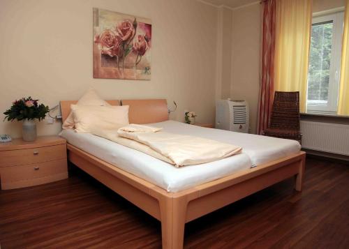 a bedroom with a bed with white sheets at Hotel-Restaurant La Fontana in Sankt Ingbert