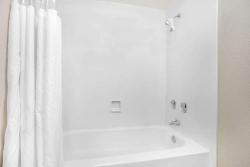 a white bath tub with a shower curtain in a bathroom at Super 8 by Wyndham Austell/Six Flags in Austell