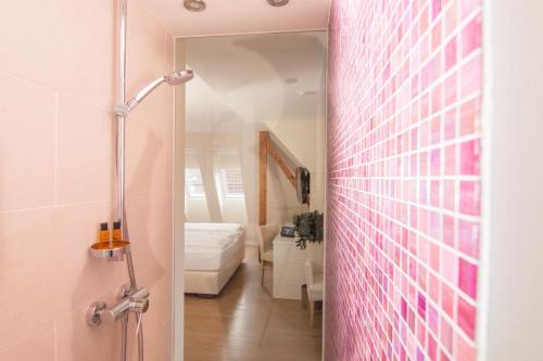 un baño con una puerta de cristal que conduce a un dormitorio en Hotel Havelser Hof, en Garbsen