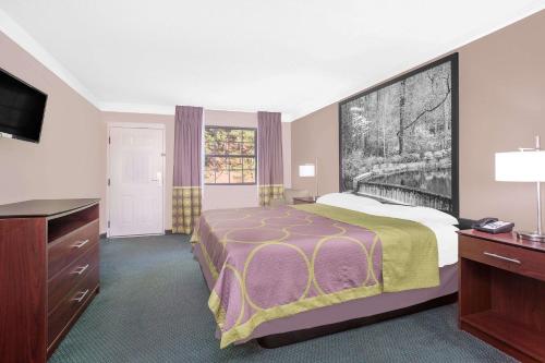 a hotel room with a bed and a flat screen tv at Super 8 by Wyndham Austell/Six Flags in Austell