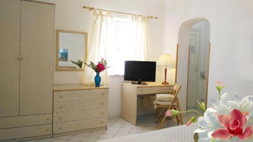 a living room with a dresser and a television at Hotel Villa Augustus in Lipari