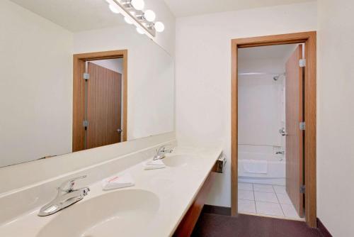een witte badkamer met een wastafel en een spiegel bij Super 8 by Wyndham Keystone/Mt. Rushmore in Keystone