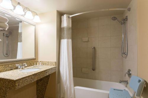 y baño con bañera, lavamanos y ducha. en Wingate by Wyndham Dayton - Fairborn en Fairborn