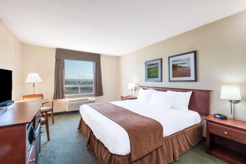 A bed or beds in a room at Super 8 by Wyndham Windsor NS