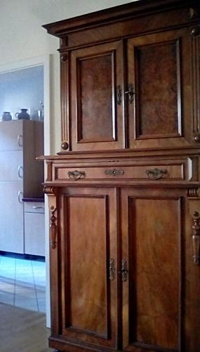 a large wooden cabinet in a room at Bastians Herberge in Leipzig