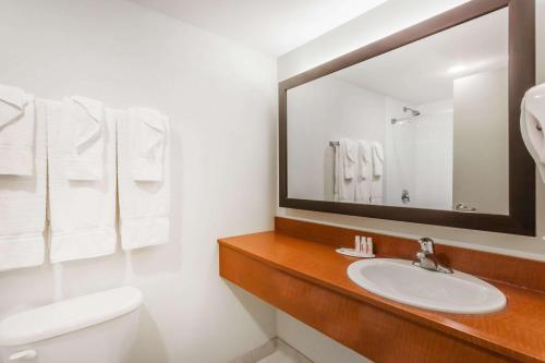 a bathroom with a sink and a mirror at Super 8 by Wyndham Peterborough in Peterborough