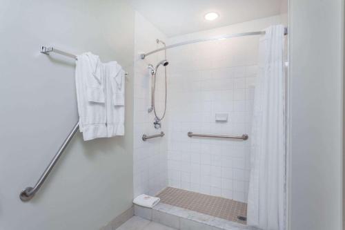 a white bathroom with a shower and a toilet at Super 8 by Wyndham Peterborough in Peterborough
