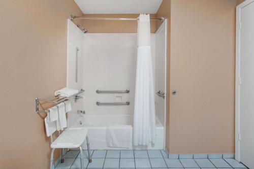 y baño con ducha y cortina de ducha. en Super 8 by Wyndham Bastrop TX, en Bastrop