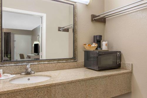 a bathroom with a sink and a television on a counter at Super 8 by Wyndham Antioch/Nashville South East in Antioch