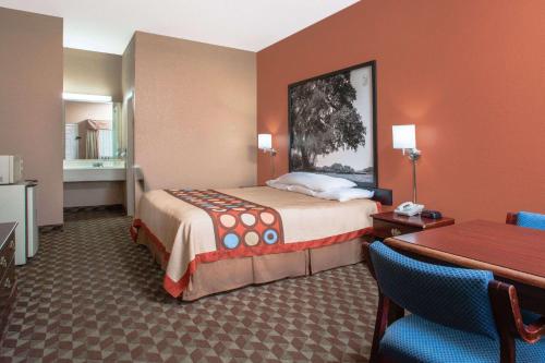 Habitación de hotel con cama, mesa y sillas en Super 8 by Wyndham Bastrop TX, en Bastrop