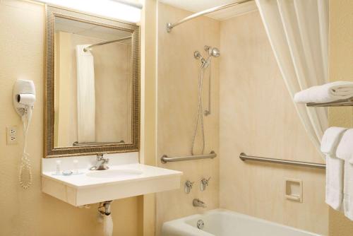 La salle de bains est pourvue d'un lavabo, d'une douche et d'une baignoire. dans l'établissement Travelodge by Wyndham Sturgis, à Sturgis