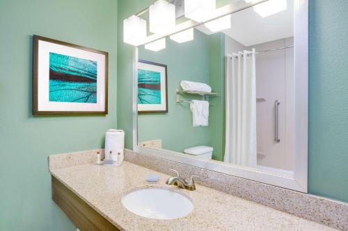 W łazience znajduje się umywalka i lustro. w obiekcie Wingate by Wyndham Bossier City w mieście Bossier City