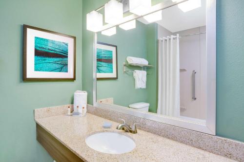a bathroom with a sink and a mirror at Wingate by Wyndham Bossier City in Bossier City