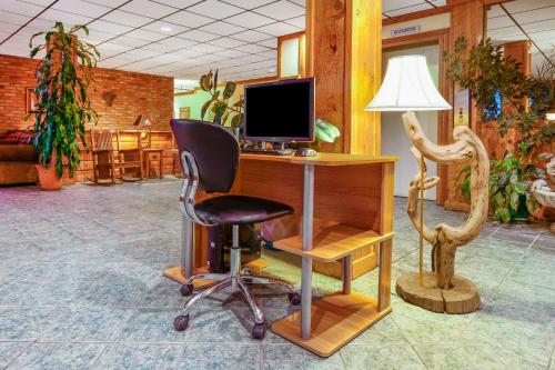 a desk with a computer and a chair in a room at Longhorn Hotel in Helena