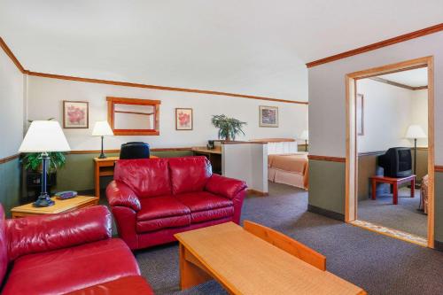 a hotel room with a red couch and a living room at Longhorn Hotel in Helena